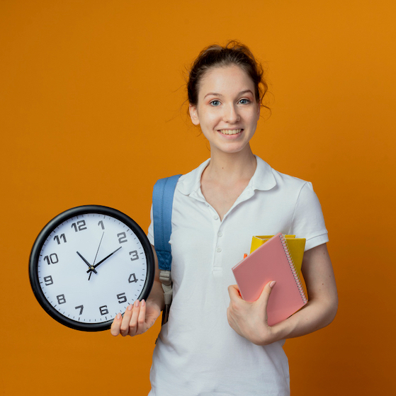 Time mngt Smiling young pretty female student wearing back bag holding note pad book and clock isolated on orange background with copy space sq